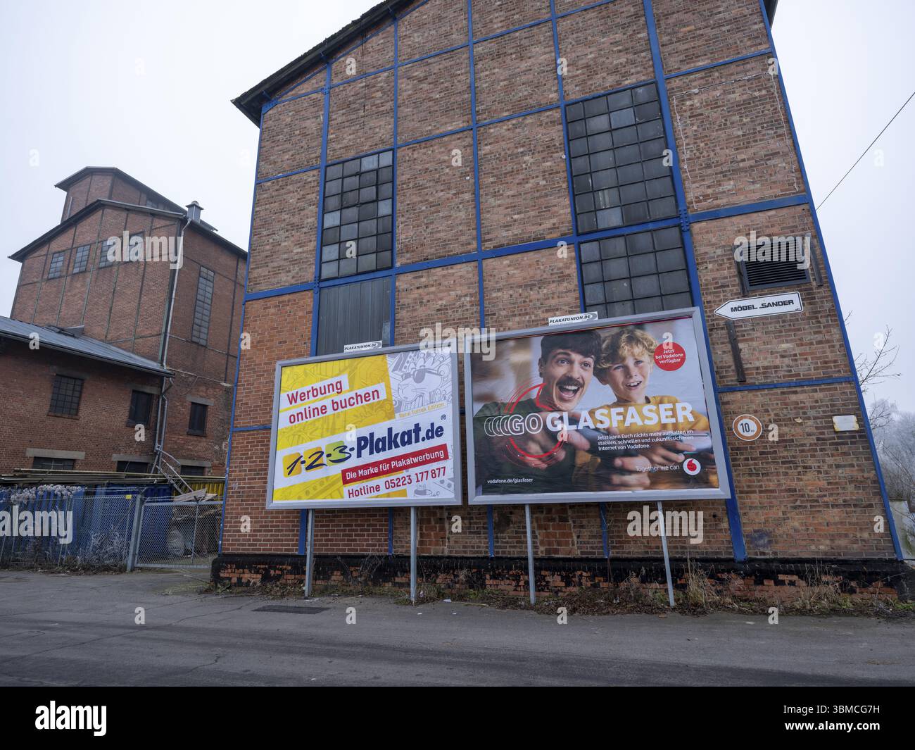 Grandes affiches avec de la publicité pour les panneaux d'affichage et la fibre optique de Vodafone sur le mur d'un bâtiment industriel, Braunschweig, basse-Saxe, allemand Banque D'Images