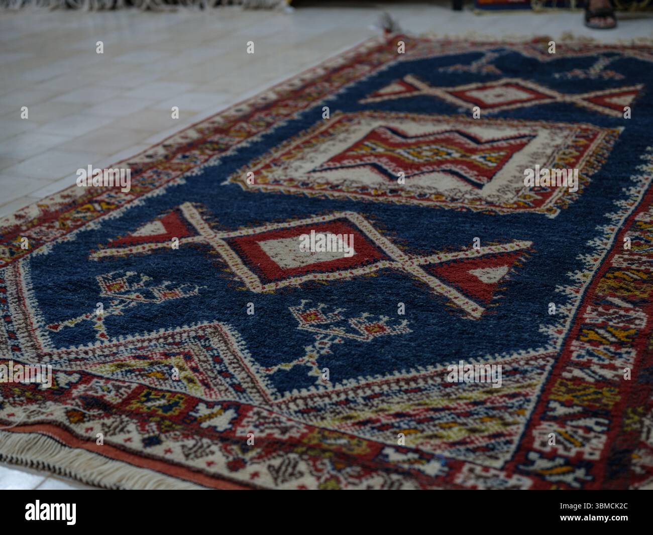 Maroc, Merzouga, 04 juillet 2025. Intérieur d'un atelier de tapis berbère traditionnel dans la région du Sahara, décoré de tapis colorés faits à la main et de weav Banque D'Images