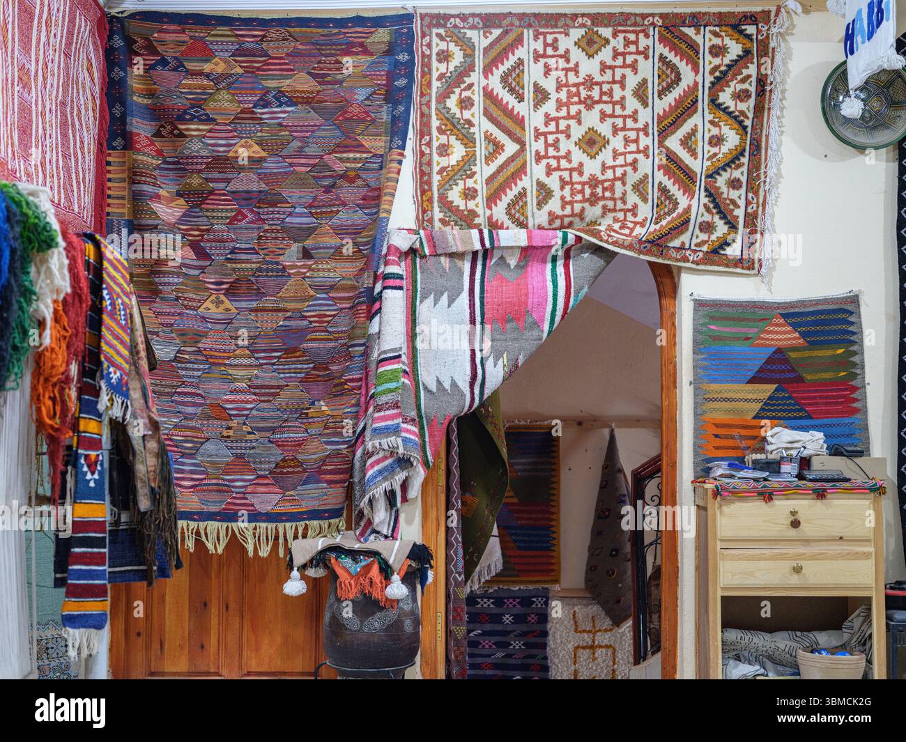 Maroc, Merzouga, 04 juillet 2025. Intérieur d'un atelier de tapis berbère traditionnel dans la région du Sahara, décoré de tapis colorés faits à la main et de weav Banque D'Images