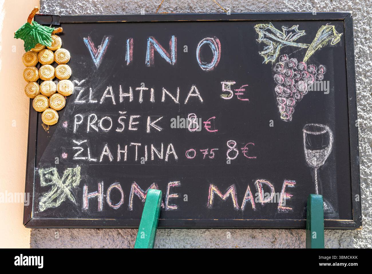 Une planche devant un magasin de spiritueux local avec des informations sur les prix des spiritueux et du vin, le vin Żlahtina doré de Vrbnik sur l'île de Banque D'Images