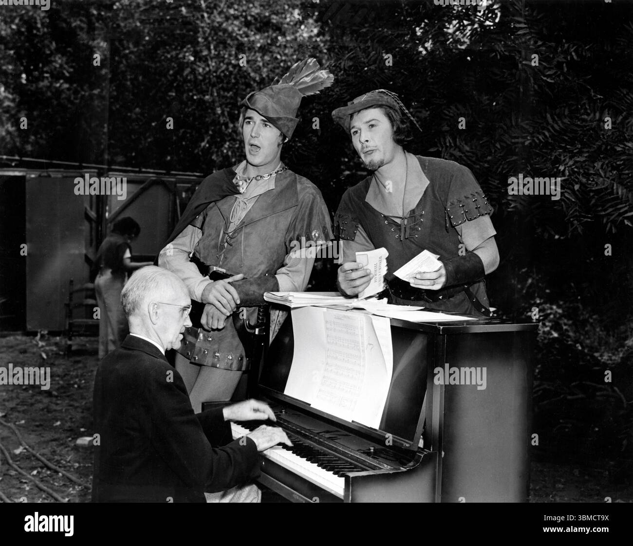 PATRIC KNOWLES et ERROL FLYNN sur le lieu de tournage chantent au piano près de Chico, Californie pendant le tournage des AVENTURES DES réalisateurs de ROBIN HOOD 1938 MICHAEL CURTIZ et WILLIAM KEIGHLEY scénario original Norman Reilly Raine et Seton I. Miller musique Erich Wolfgang Korngold costumier Milo Anderson A Warner Bros - First National Picture Banque D'Images