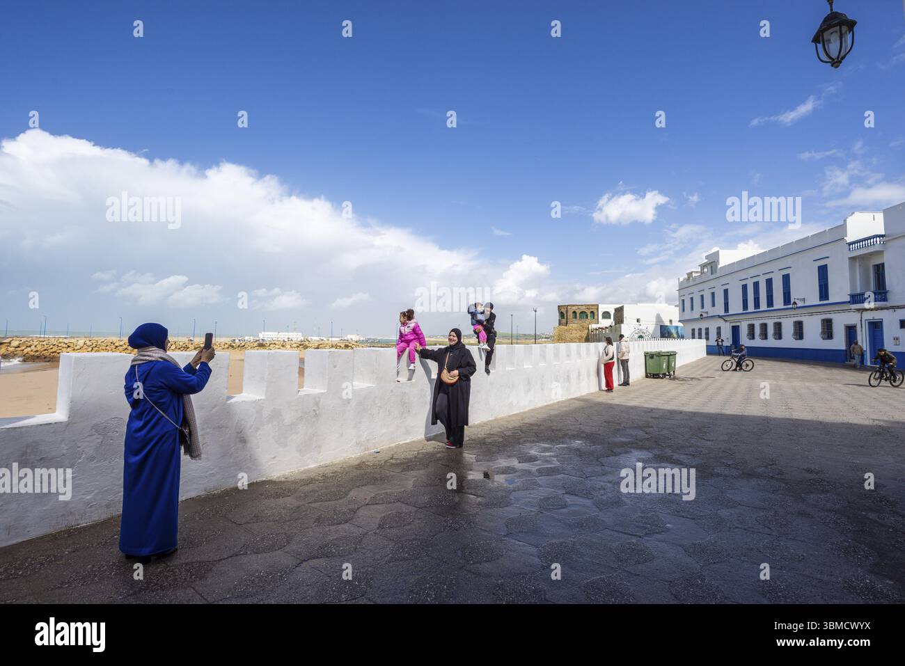 Touristes marchant le long du mur portugais par la mer, Asilah, Maroc, Afrique du Nord, Afrique Banque D'Images