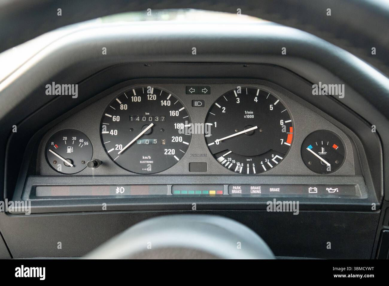 Une vue détaillée présentant un tableau de bord de voiture vintage classique avec indicateur de vitesse, jauge de carburant et témoins d'avertissement Banque D'Images