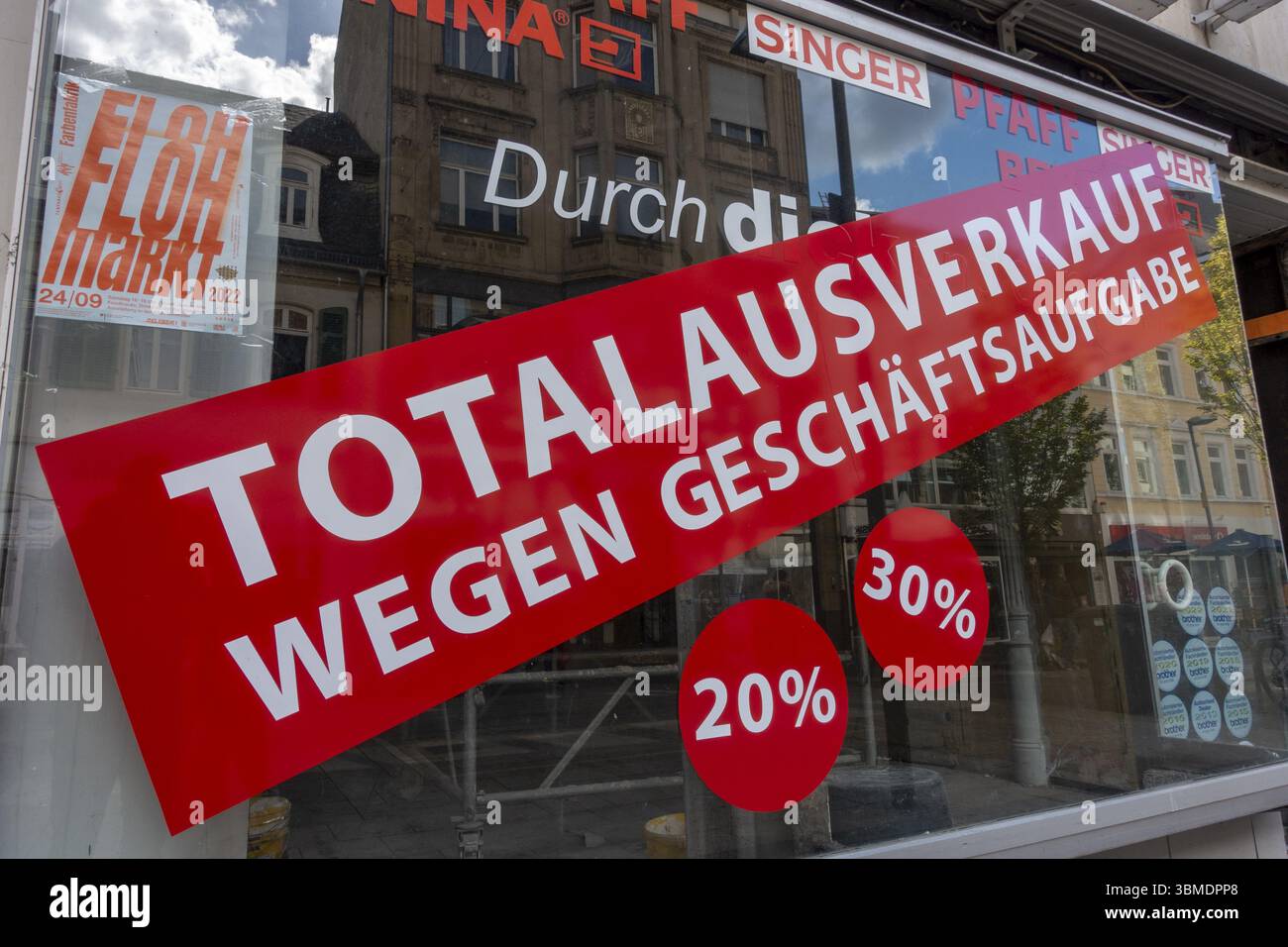 Vente totale due à la fermeture de l'entreprise, grand autocollant rouge sur la vitrine d'un magasin de machines à coudre et de laine dans la zone piétonne, Offenbach am main, Banque D'Images