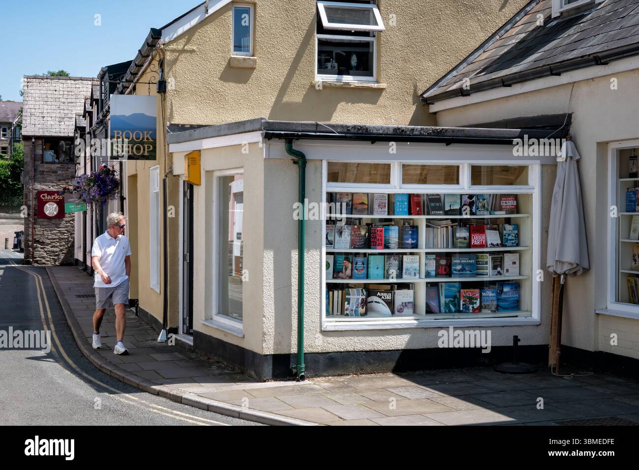 Brecon, pays de Galles, Royaume-Uni. Un homme passe devant une librairie indépendante et regarde la vitrine de la rue comme il passe Banque D'Images