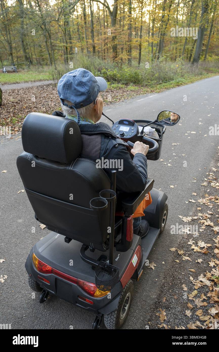 Un retraité de 92 ans roule en fauteuil roulant électrique sur la route, Allemagne, Europe Banque D'Images