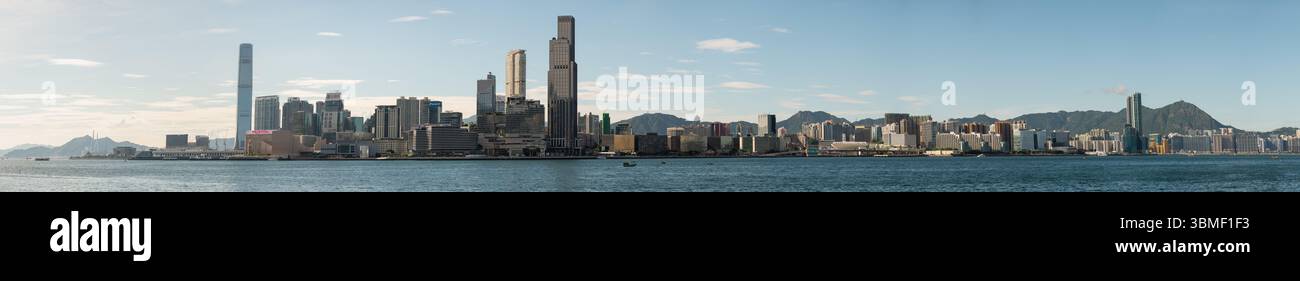 Vue panoramique sur le port Victoria à Hong Kong, avec un horizon époustouflant de gratte-ciel juxtaposé à la beauté naturelle de mountai environnant Banque D'Images