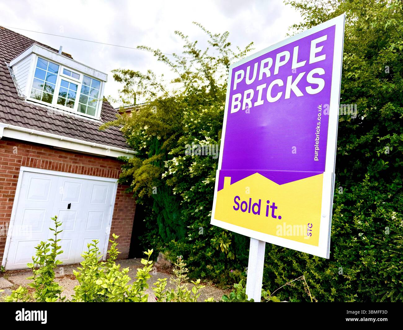 Une enseigne Purple Bricks Estate agent devant une maison au Royaume-Uni Banque D'Images