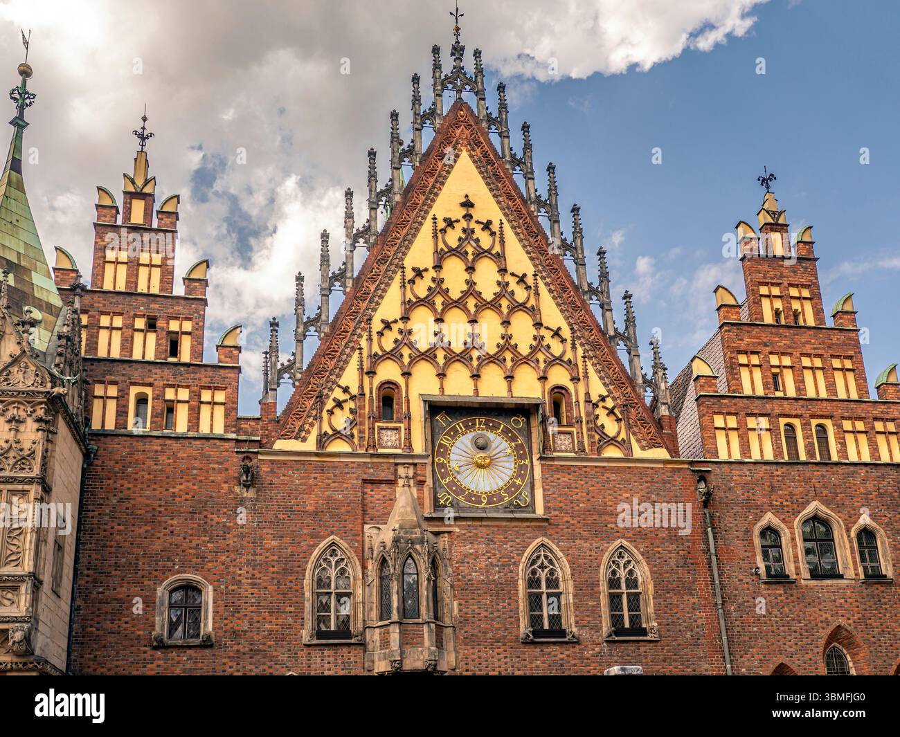 Une scène vibrante avec une maison de ville historique avec tour de l'horloge entourée de charmants bâtiments colorés sous un ciel bleu ensoleillé et parsemé de nuages, Wrocla Banque D'Images