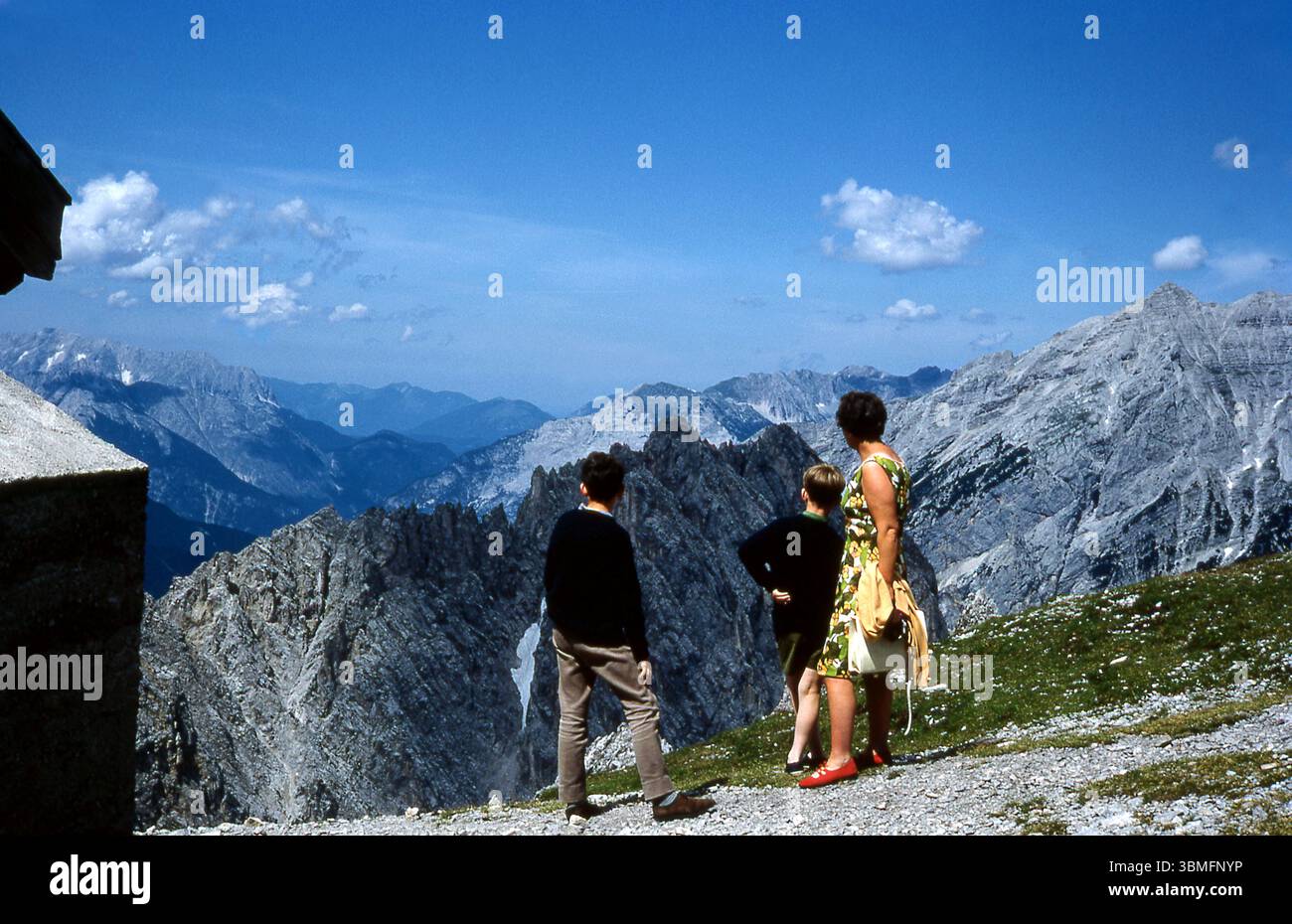 Années 1960 Autriche - mère et deux fils surplombant un terrain accidenté sur une chaîne de montagnes dans le parc national de Karwendel près d'Innsbruck en 1967 Banque D'Images