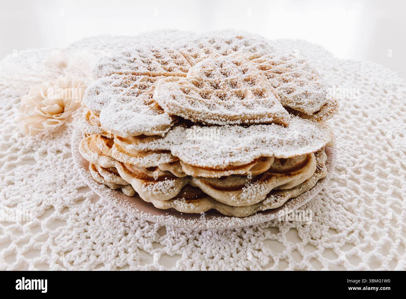 Pile de gaufres coeur fraîchement cuites, maison avec sucre en poudre, style minimaliste et vintage Banque D'Images