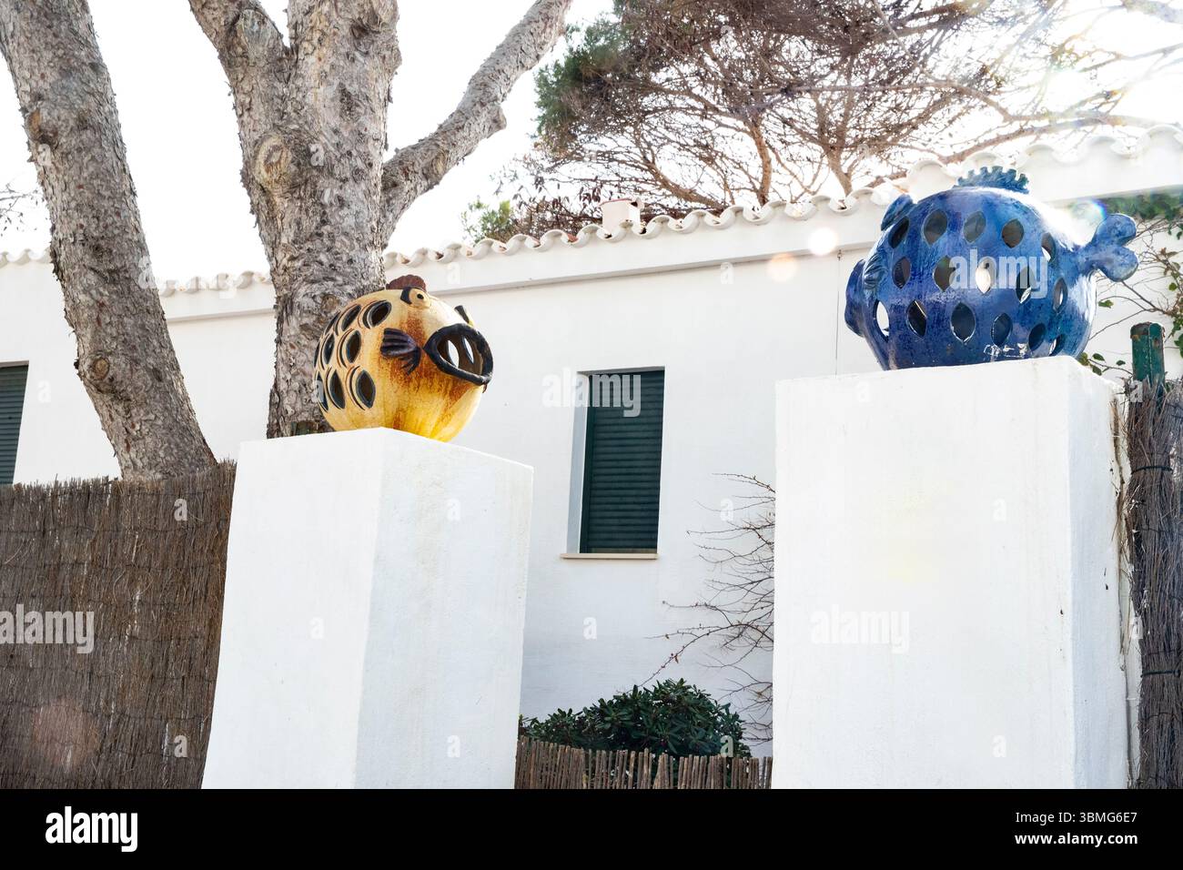 Lanternes de poisson en céramique à l'entrée de la maison. Décor lumineux, poisson décoratif sur des poteaux à Minorque, Espagne 03.08.2025 Banque D'Images