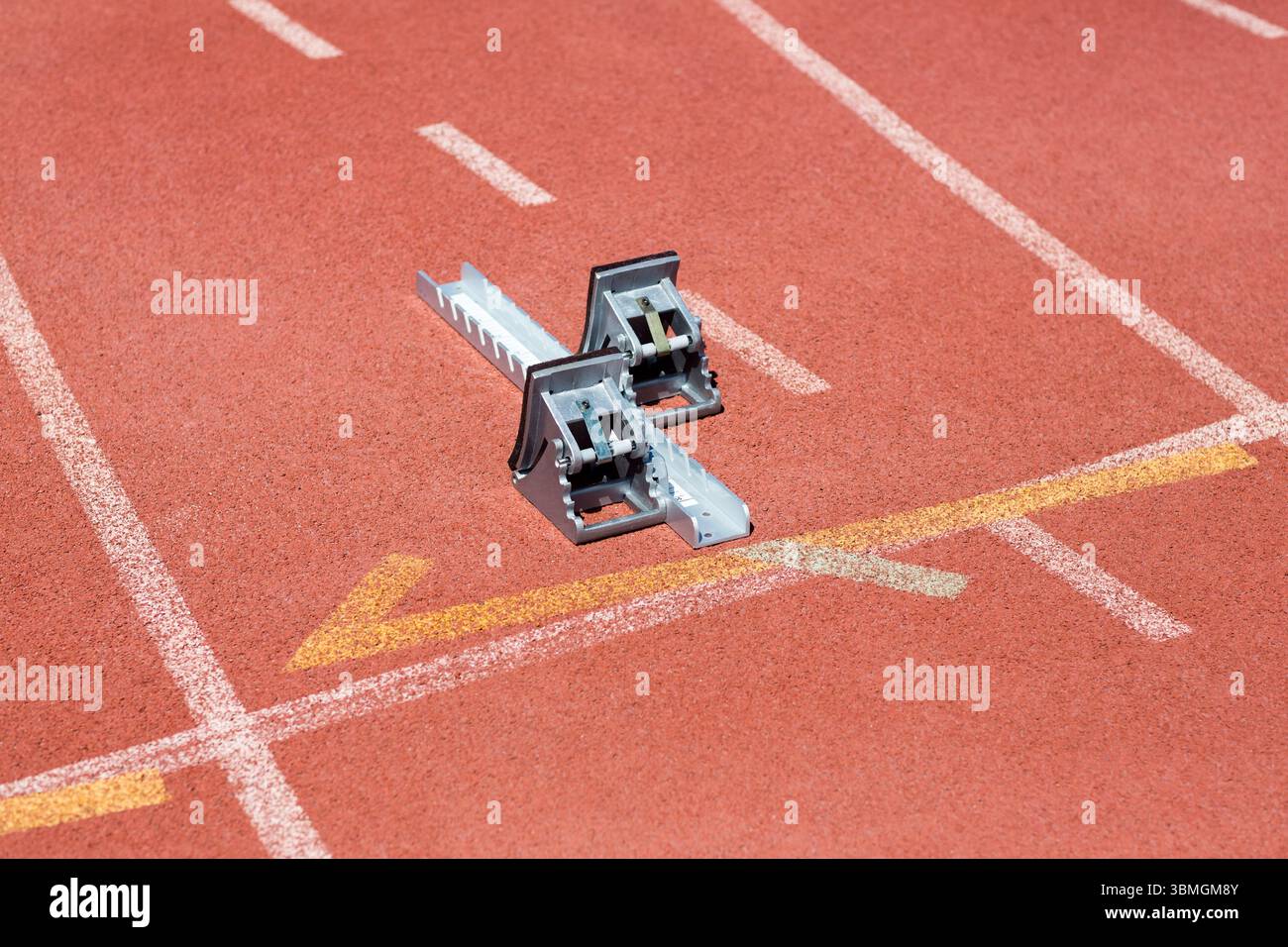 le bloc de départ en métal repose sur la voie rouge, la conception de vecteur plat montrant des voies blanches, flèche jaune Banque D'Images