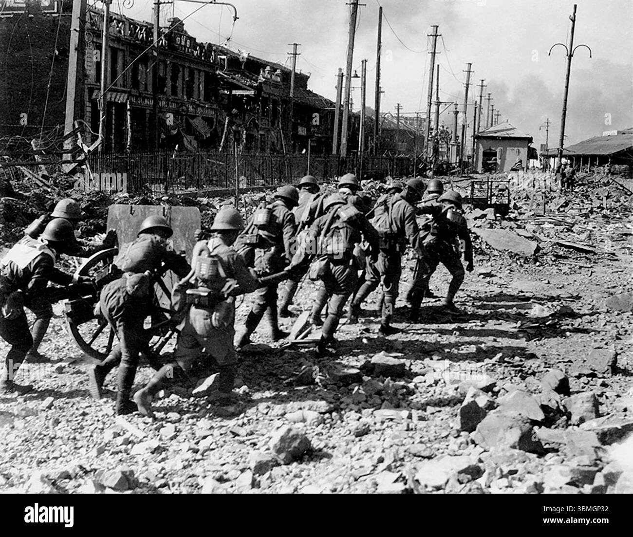 Photographie d'un groupe de soldats marchant à travers Shanghai détruit pendant la seconde guerre sino-japonaise de 1937 à 1945. Bataille de Shanghai.1937 Banque D'Images