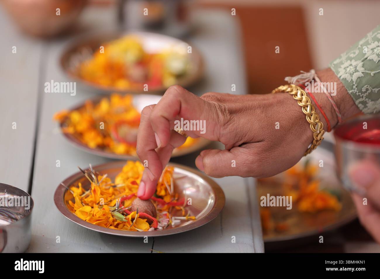 Un moment clé d’un rituel hindou ou d’une cérémonie de mariage, mettant l’accent sur l’application de kumkum (poudre vermillon) dans le cadre d’une offrande sacrée. Banque D'Images