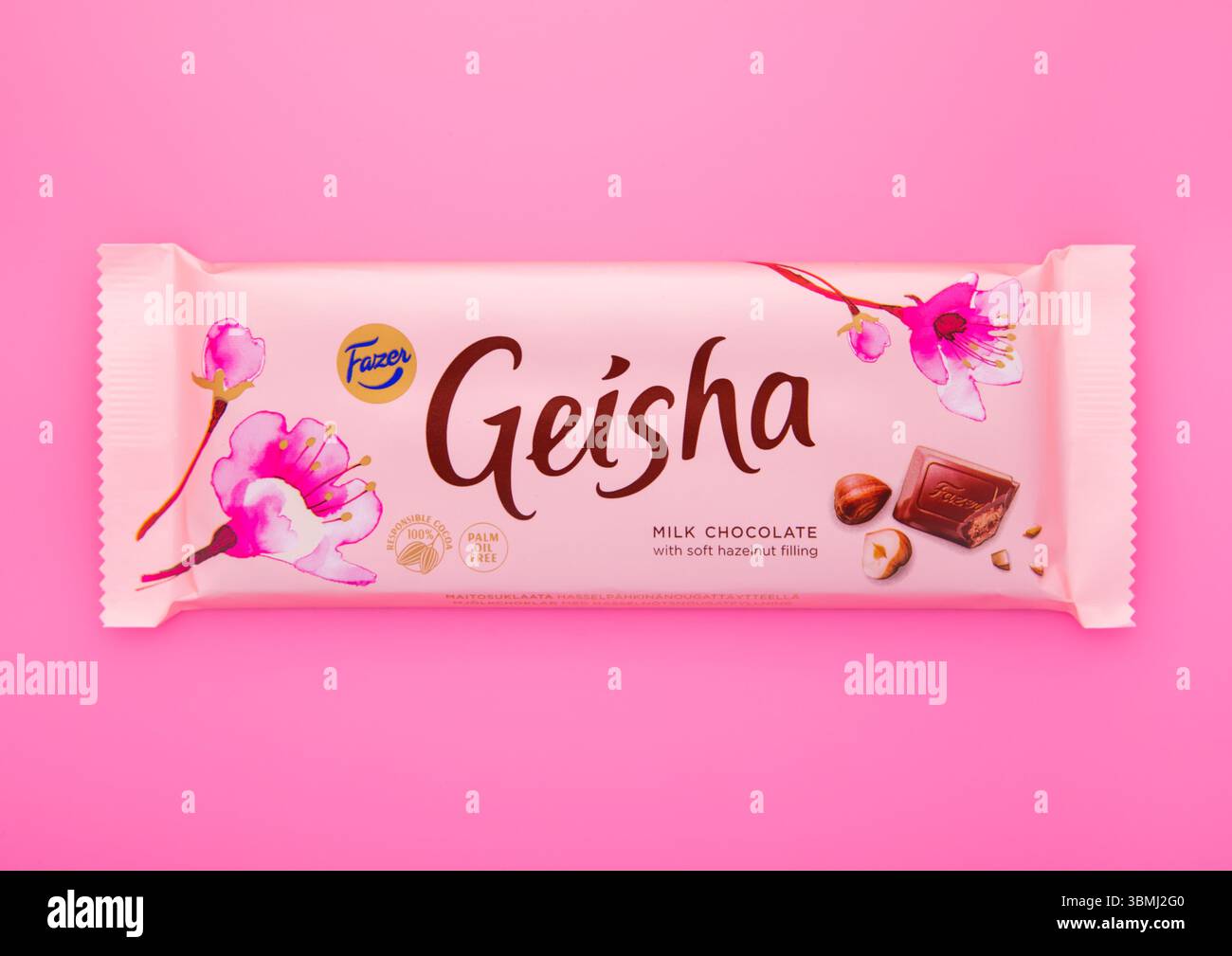 LONDRES, Royaume-Uni - 02 FÉVRIER 2025 : chocolat au lait Geisha et barre de noisettes molles sur fond rose. Banque D'Images
