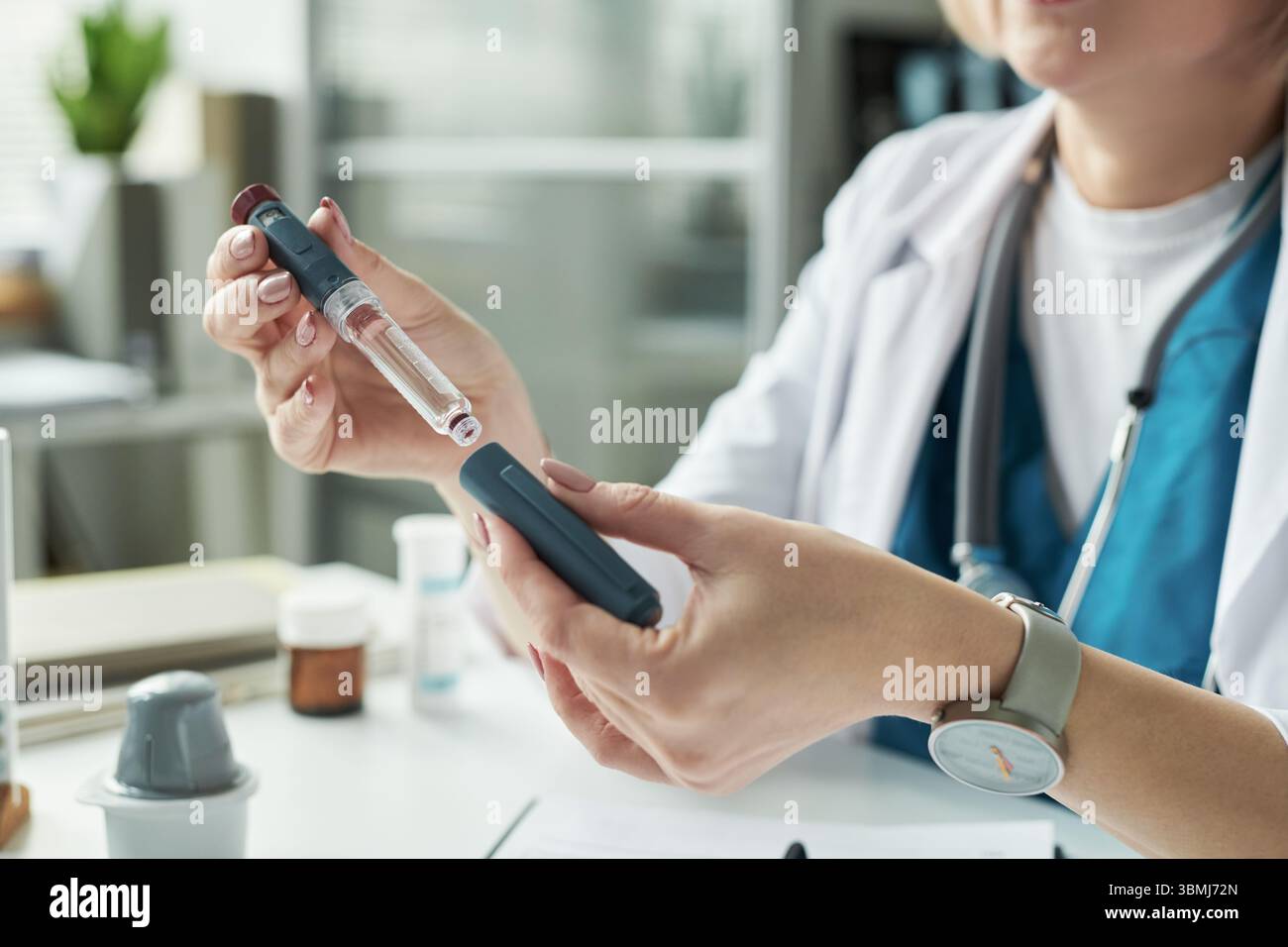 Caucasien femme d'âge moyen préparant l'injection d'insuline pour le traitement du diabète dans le cabinet médical, tenant le stylo d'insuline et le flacon tandis que l'explainin Banque D'Images