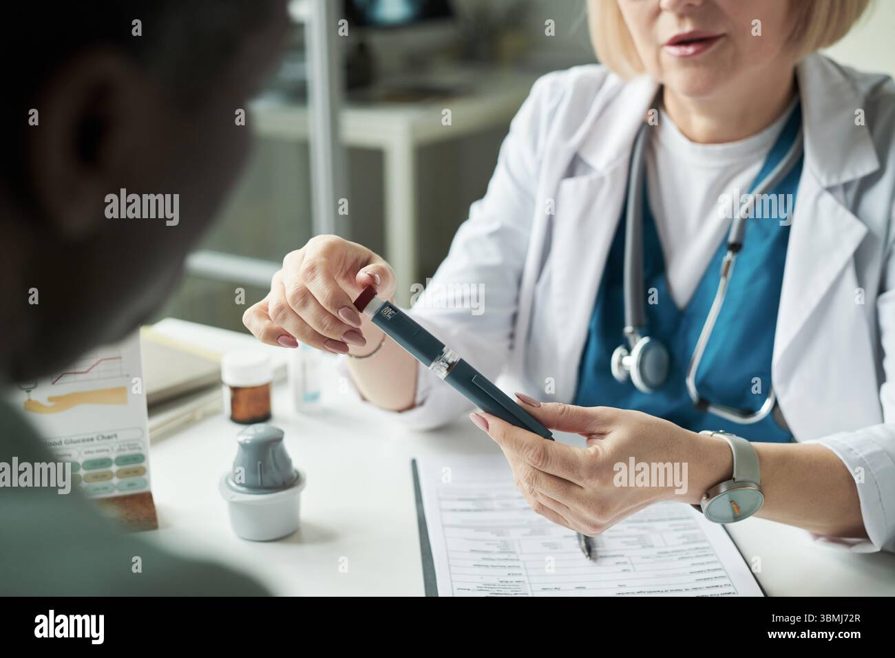 Caucasien médecin féminin d'âge moyen expliquant l'utilisation du lecteur de glycémie à l'homme d'âge moyen noir pendant la consultation de diabète dans le cabinet médical, han Banque D'Images