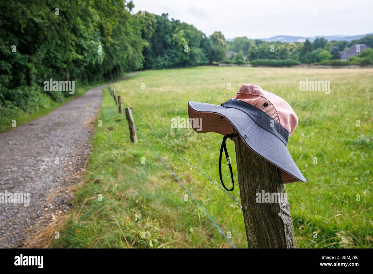 Chapeau suspendu au-dessus d'un poteau de clôture sur un chemin du Ruhrhoehenweg dans l'Ardeygebirge près de Wetter an der Ruhr, Rhénanie du Nord-Westphalie, Allemagne. ein Hut h Banque D'Images