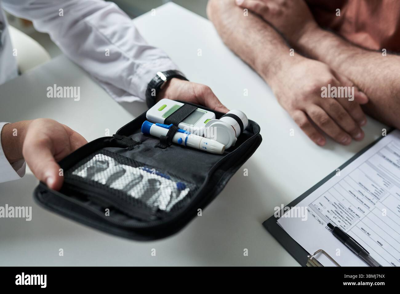 Homme caucasien d'âge moyen assis à un bureau avec un médecin masculin montrant un kit de surveillance du diabète comprenant un glucomètre et un stylo à insuline pendant la consultation médicale Banque D'Images