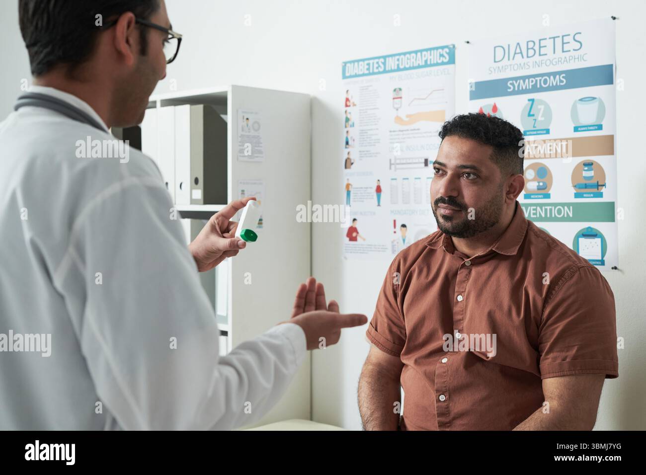 Homme caucasien d'âge moyen assis dans le cabinet médical écoutant le médecin masculin expliquant les options de traitement du diabète avec stylo d'insuline, infograp de diabète Banque D'Images
