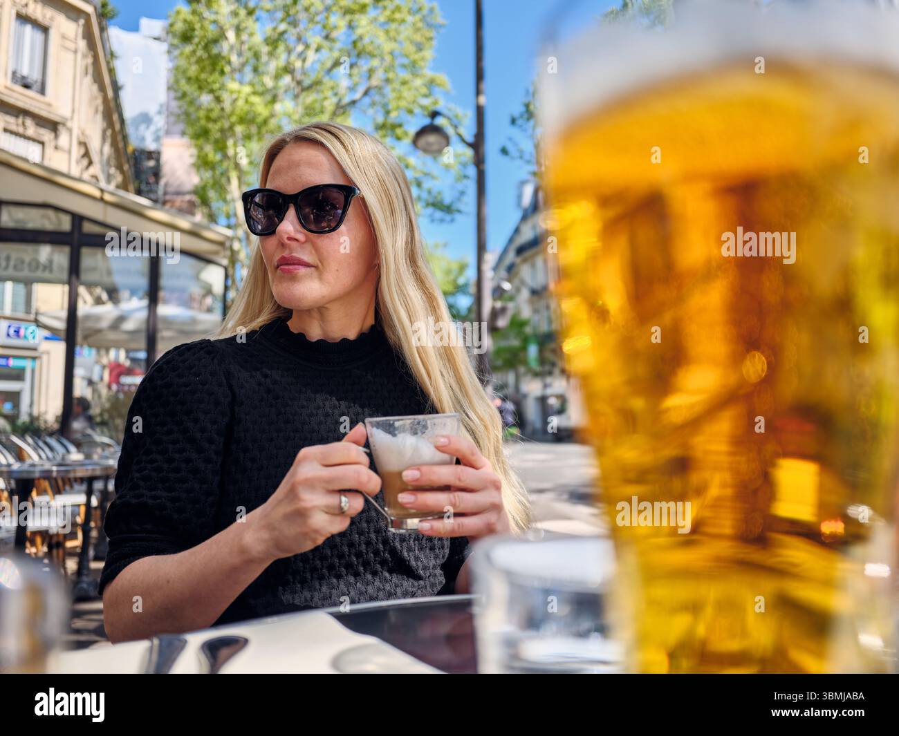 Femme d'affaires buvant cappuccino et bière au café en plein air Banque D'Images