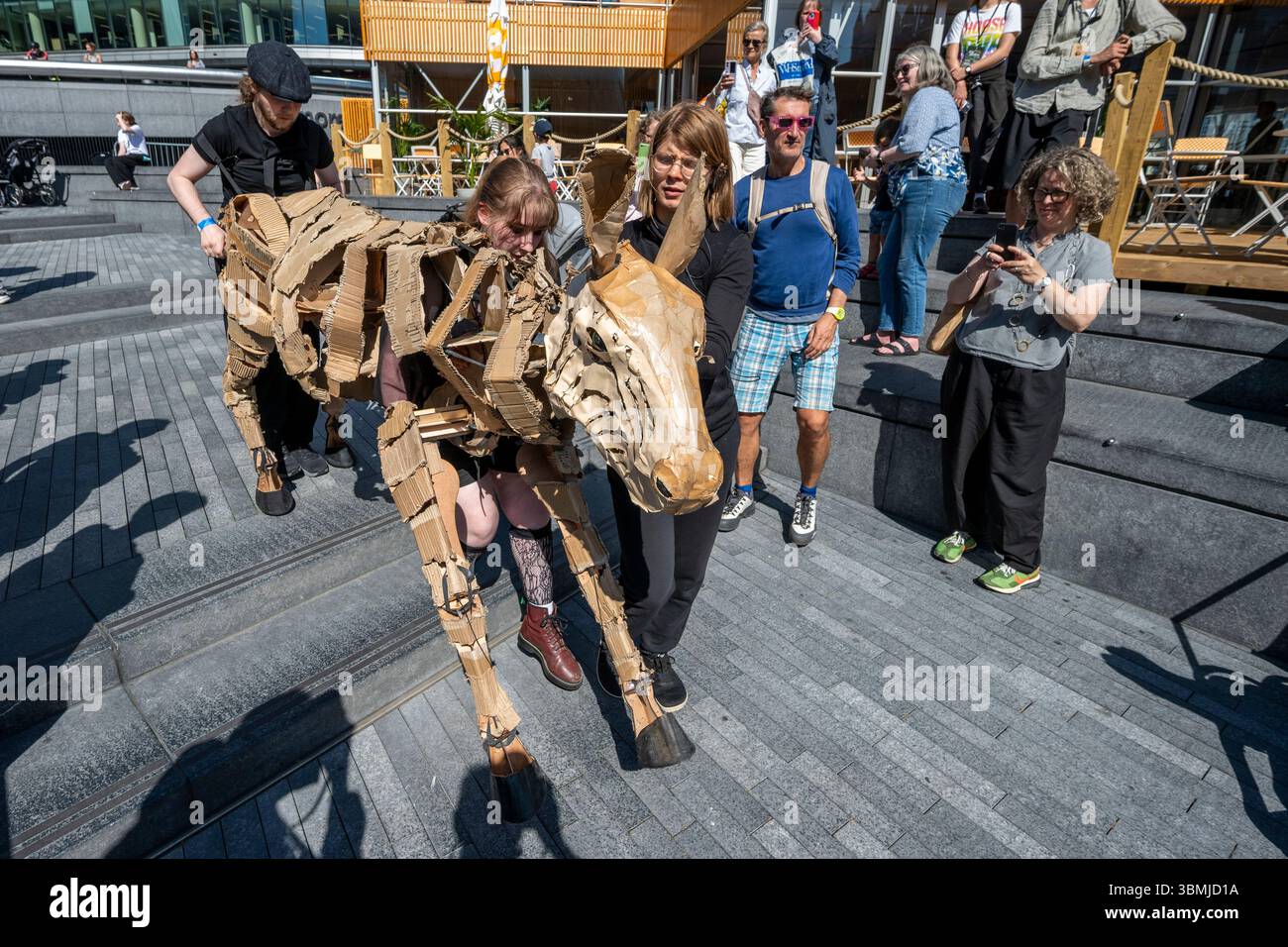 Londres, Royaume-Uni. 27 juin 2025. Les marionnettistes se produisent lors d’une conférence téléphonique près de Tower Bridge for THE HERDS, une nouvelle œuvre d’art majeure qui voit des animaux marionnettes grandeur nature voyager, d’avril à août 2025, sur une route de 20 000 km entre le bassin du Congo et le cercle arctique, symbolisant leur fuite d’une catastrophe climatique. Gorilles, lions, zèbres et kudus sont arrivés à Londres pour le week-end avant de passer à Manchester. Credit : Stephen Chung / Alamy Live News Banque D'Images