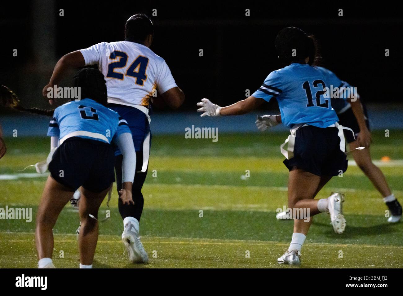 Drapeau joueur de football court vers la zone d'extrémité pendant que les adversaires donnent la chasse Banque D'Images