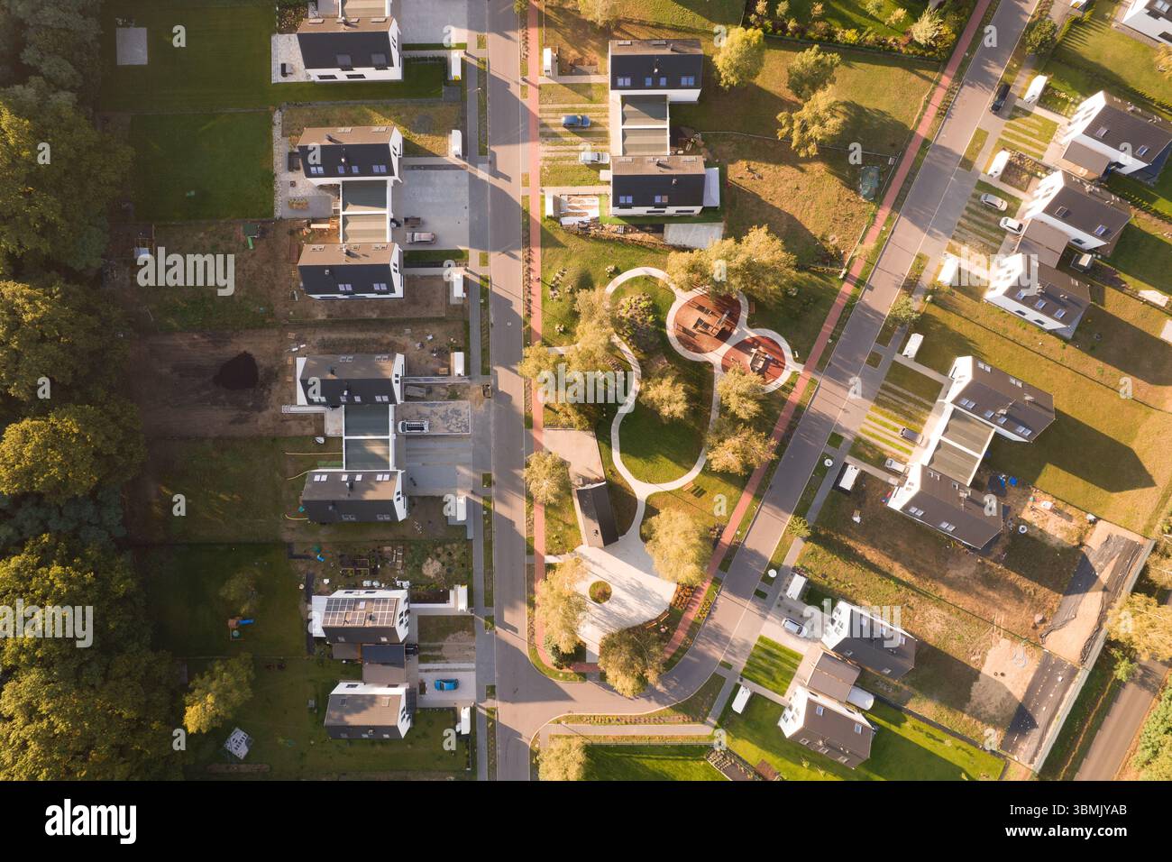Vue aérienne de haut en bas par drone d'un quartier résidentiel moderne nouvellement construit. Le lotissement est conçu avec un parc vert central avec un Banque D'Images