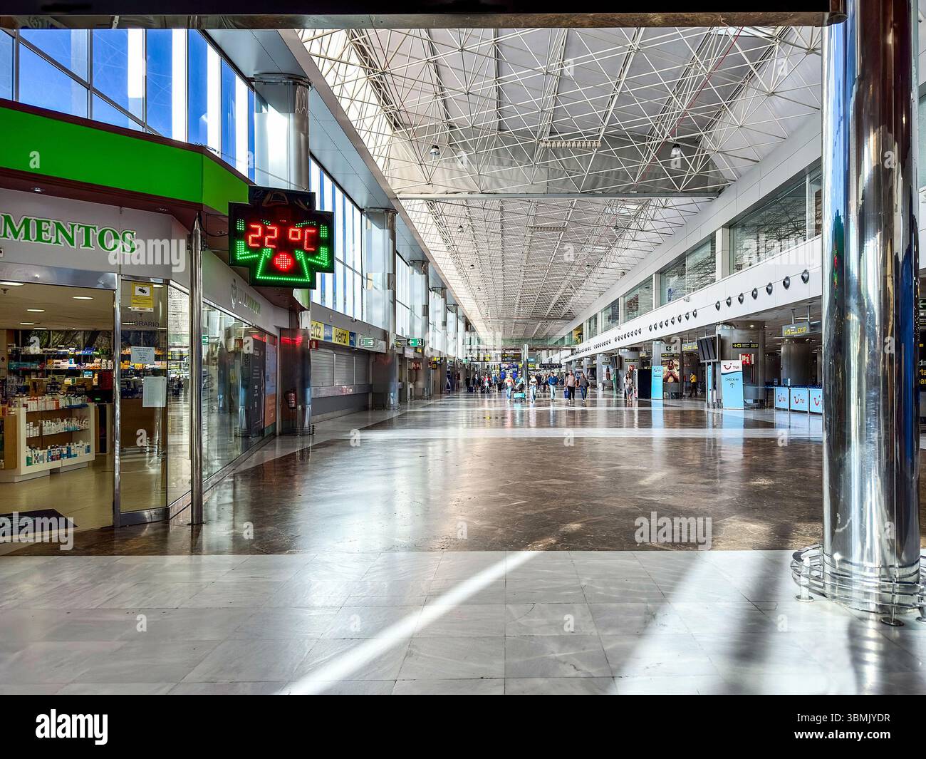 Intérieur du terminal de l'aéroport de Teneri avec pharmacie, horloge numérique montrant la température des gens marchant dans le fond de l'aéroport de tenerife-sur tenerife espagne - Image de stock capturée avec un smartphone