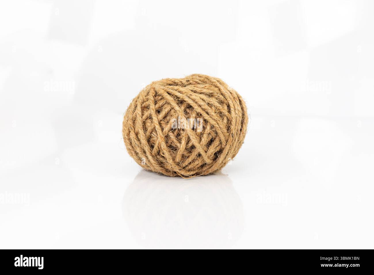 Gros plan de boule de ficelle de jute sur fond blanc Banque D'Images
