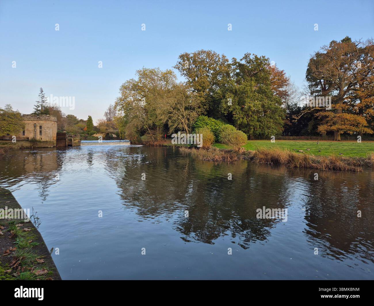 Vue calme sur la rivière près du château de Warwick avec des arbres d'automne reflétés dans la rivière Avon à Warwick, Warwickshire, Angleterre. - Image de stock capturée avec un smartphone