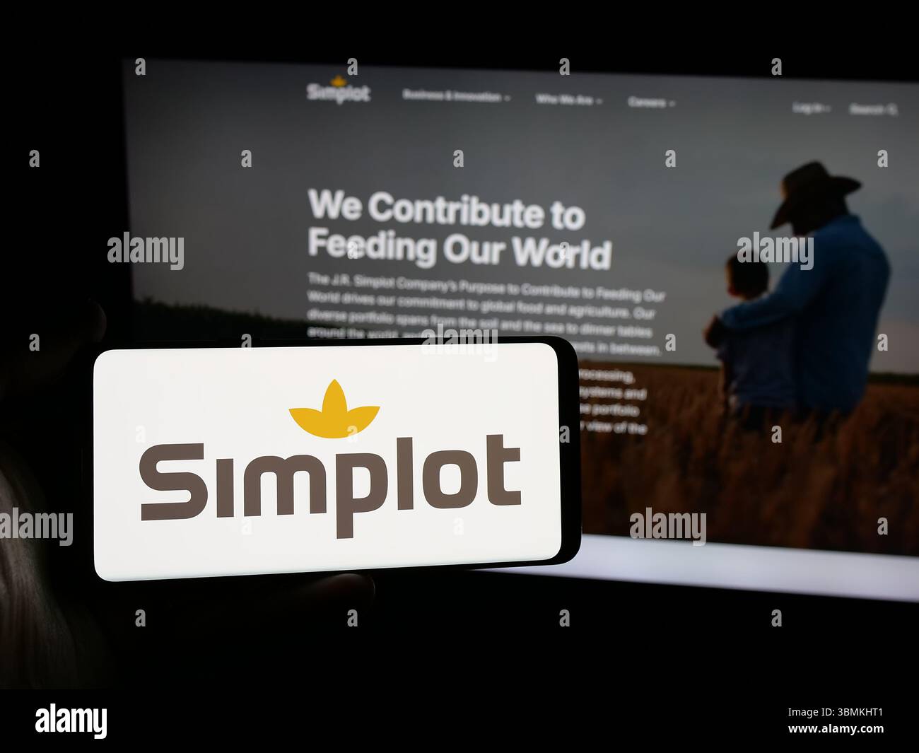 Stuttgart, Allemagne - 04-26-2025, personne tenant un smartphone avec le logo de US Agri-business J. R. Simplot Company sur l'écran devant le site Web. Banque D'Images