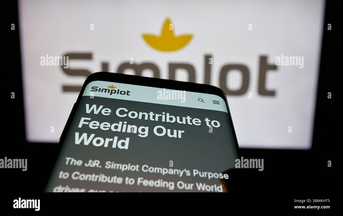 Stuttgart, Allemagne - 04 26 2025 : téléphone portable avec la page web de la société agro-alimentaire américaine J. R. Simplot sur l'écran devant le logo. Banque D'Images