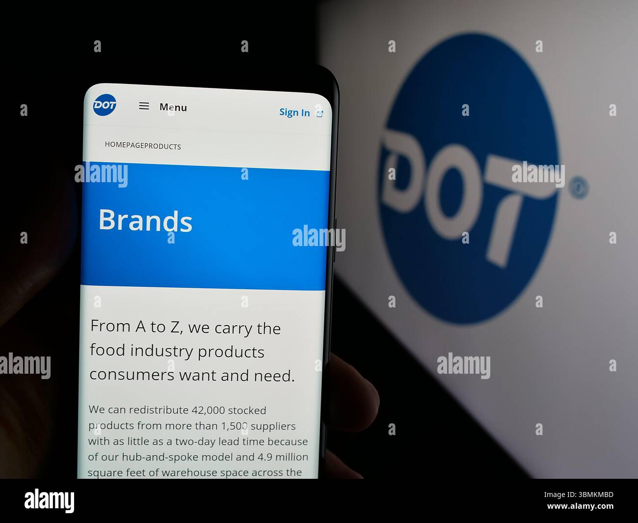 Stuttgart, Allemagne - 05-02-2025 : personne tenant un smartphone avec le site Web de la société américaine de restauration Dot Foods Inc. sur l'écran devant le logo. Banque D'Images