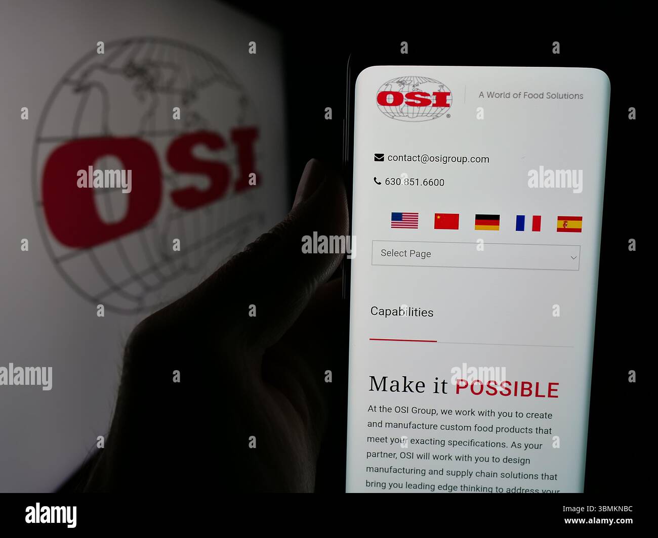 Stuttgart, Allemagne - 05-02-2025 : personne tenant un smartphone avec le site Web de la société américaine de transformation de viande OSI Group LLC sur l'écran devant le logo. Banque D'Images