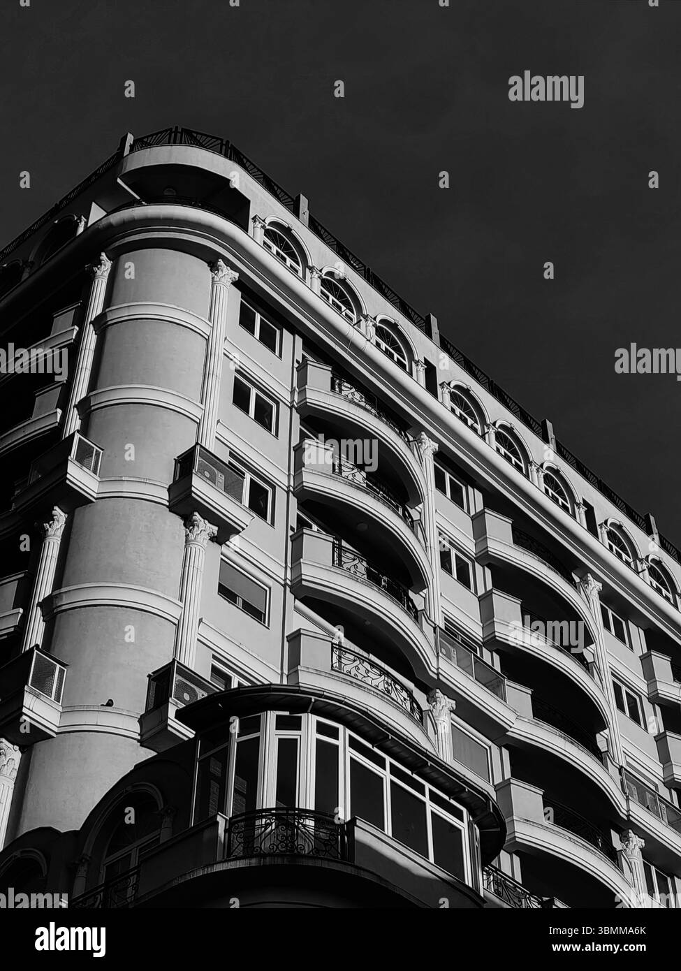 Immeuble d'appartements moderne avec balcons au coucher du soleil. Angle bas, perspective. Banque D'Images