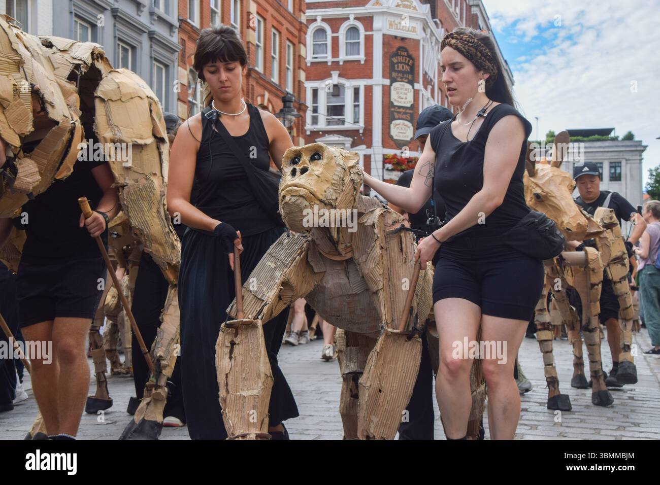 Londres, Royaume-Uni. 27 juin 2025. Les marionnettistes marchent avec des marionnettes d'animaux grandeur nature à Covent Garden, qui fait partie de l'art et de l'action climatique des « troupeaux ». Les marionnettes parcourront 20 000 km du bassin du Congo au cercle arctique, symbolisant la « fuite après le désastre climatique ». Crédit : Vuk Valcic/Alamy Live News Banque D'Images