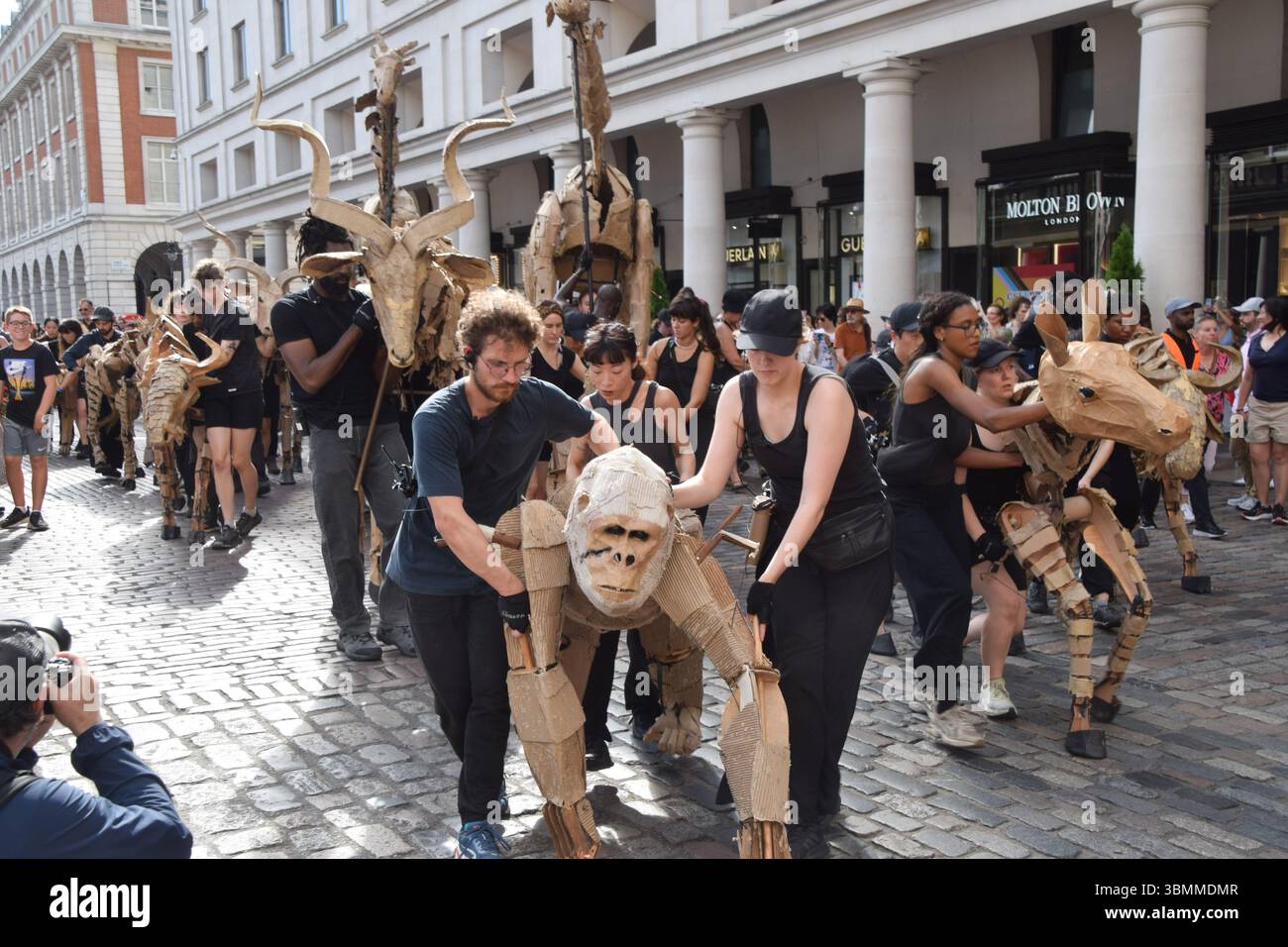 Londres, Royaume-Uni. 27 juin 2025. Les marionnettistes se produisent avec des marionnettes d'animaux grandeur nature à Covent Garden, qui fait partie de l'art et de l'action climatique des « troupeaux ». Les marionnettes parcourront 20 000 km du bassin du Congo au cercle polaire arctique, symbolisant ainsi la « fuite du désastre climatique ». Crédit : Vuk Valcic/Alamy Live News Banque D'Images