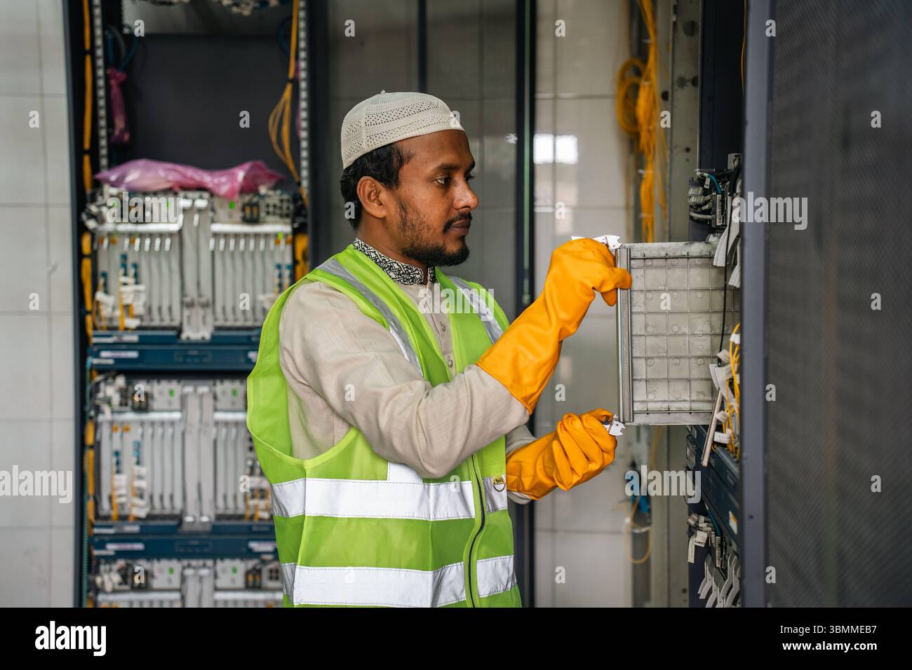 Techniciens et ingénieurs réparant les périphériques réseau, les routeurs, configurant les serveurs et réparant les câbles dans la salle réseau. Maintenance INFORMATIQUE Banque D'Images
