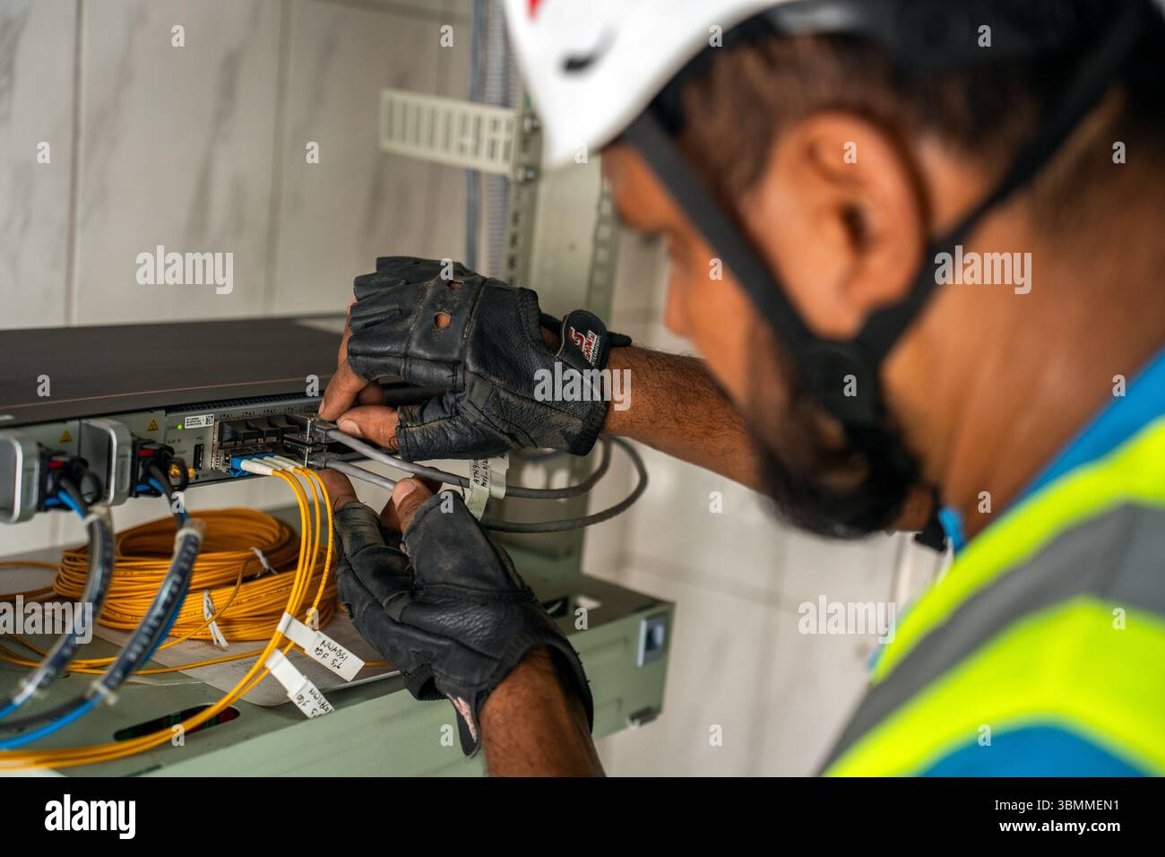 Techniciens et ingénieurs réparant les périphériques réseau, les routeurs, configurant les serveurs et réparant les câbles dans la salle réseau. Maintenance INFORMATIQUE Banque D'Images