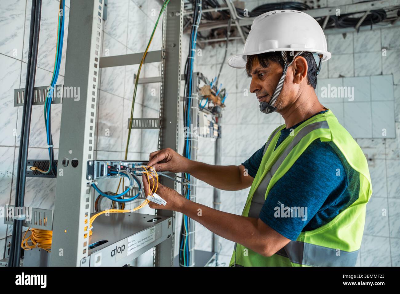 Techniciens et ingénieurs réparant les périphériques réseau, les routeurs, configurant les serveurs et réparant les câbles dans la salle réseau. Maintenance INFORMATIQUE Banque D'Images