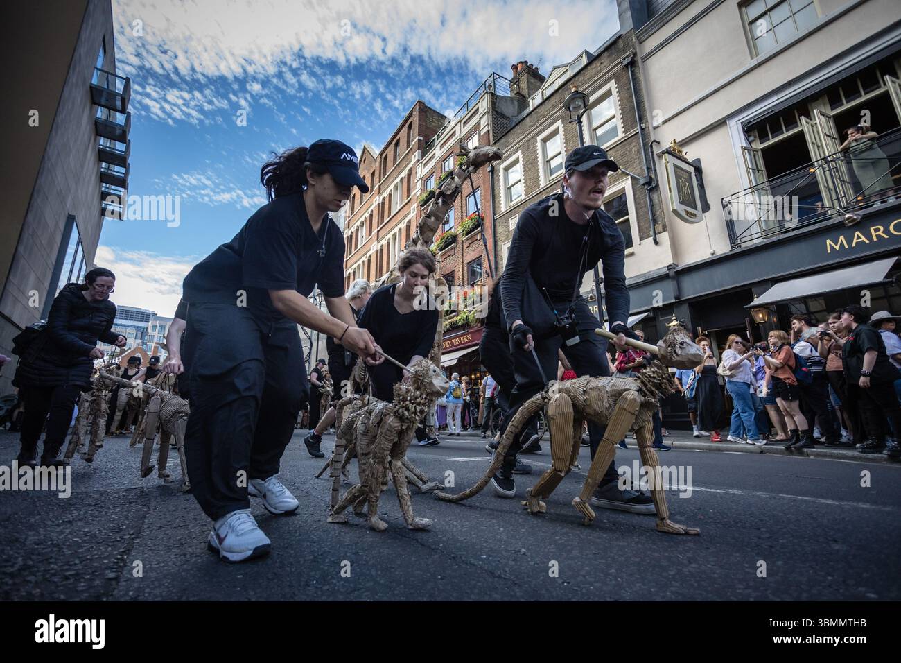 LONDRES, Royaume-Uni – 27 juin 2025 : les artistes manœuvrent des marionnettes animales en carton grandeur nature dans le West End dans le cadre des troupeaux, un publi de 20 000 kilomètres Banque D'Images