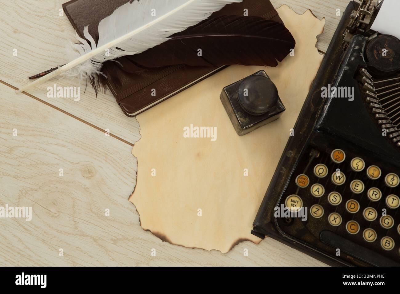 Machine à écrire, plumes et timbre sur table Banque D'Images