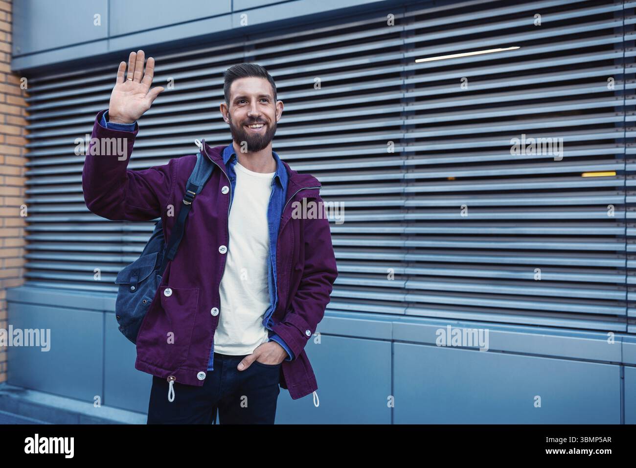 Portrait de demi-longueur beau barbu habillé dans des vêtements à la mode dans la rue alors que l'article contre la paroi arrière-plan avec salon pour la publicité Banque D'Images