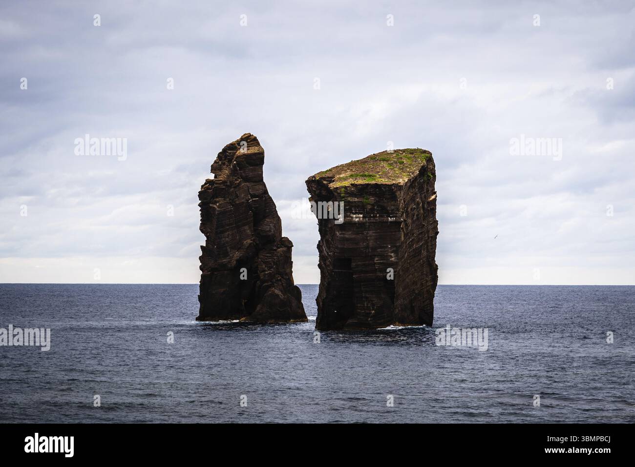 Deux îlots rocheux se dressent dans l'océan Atlantique sous un ciel nuageux, créant un paysage marin spectaculaire près de Praia dos Mosteiros, aux Açores Banque D'Images