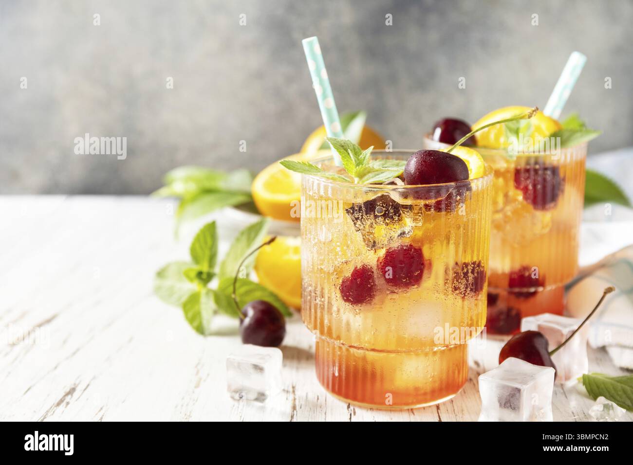Boisson fraîche d'été. Boisson rafraîchissante glacée limonade de cola cerise orange ou cocktail mojito en verre sur une table en bois. Espace de copie Banque D'Images