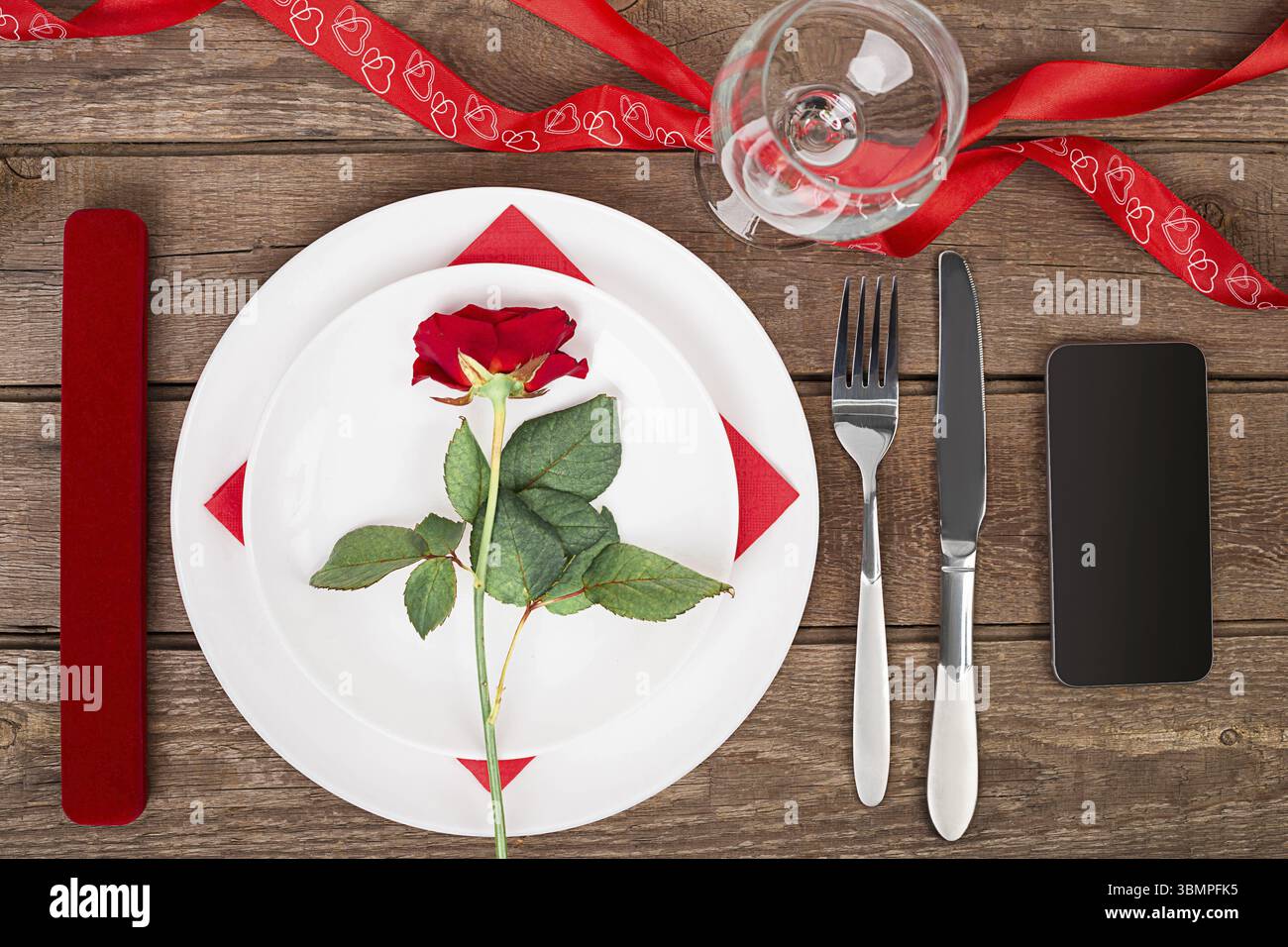 Dîner romantique concept. La Saint-Valentin ou proposition de fond. Vue de dessus du restaurant table en bois avec coeur et rose avec couverts sur l'assiette. Spa de copie Banque D'Images