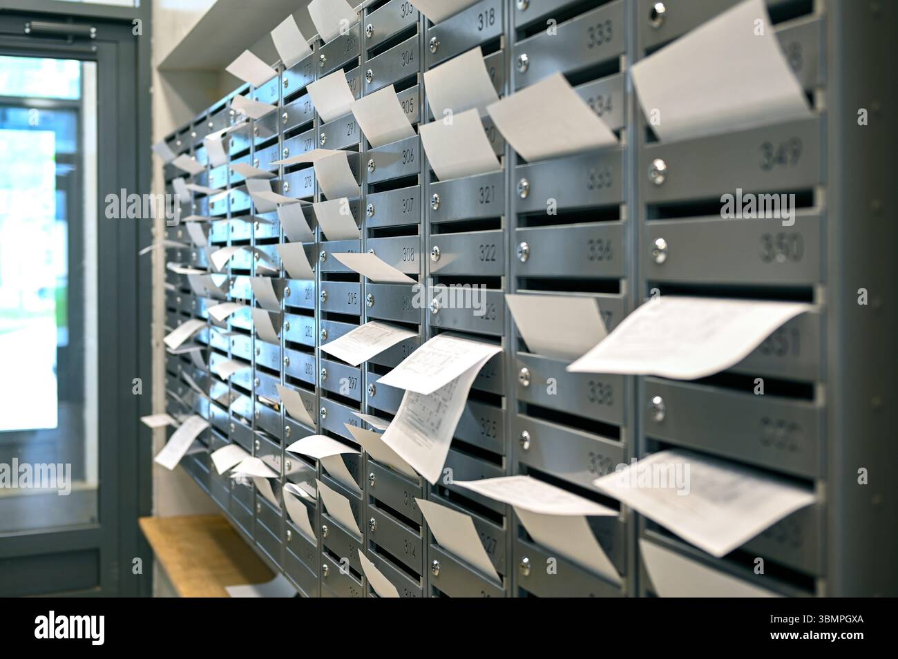 Rangées de boîtes aux lettres avec de nombreuses factures de services publics en papier Banque D'Images