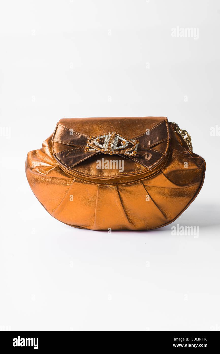 Sac à main orange fait à la main sur un fond blanc, sac à main en cuir orange fait à la main, sac à main artisanal en or orange avec une poignée courte en chaîne Banque D'Images
